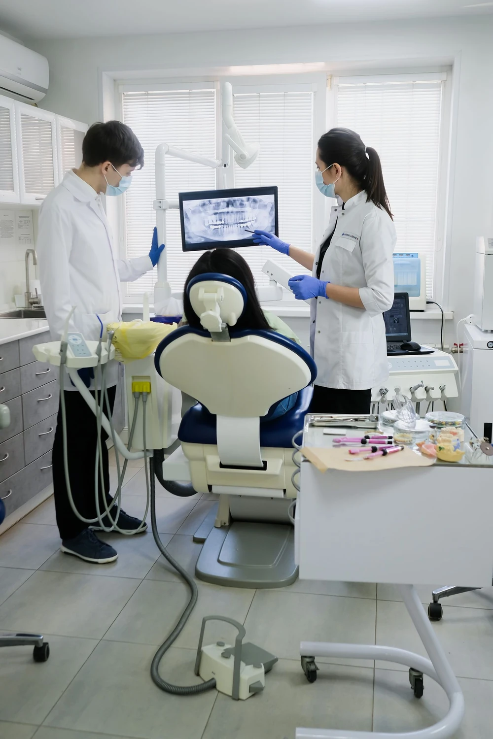 Dentistas mostrando a radiografia à paciente
